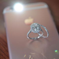 a diamond ring sitting on top of an iphone