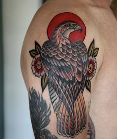 an eagle tattoo on the back of a man's left shoulder and upper arm