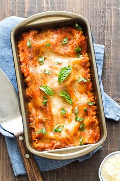 a casserole dish with meat, cheese and parsley in it on a wooden table