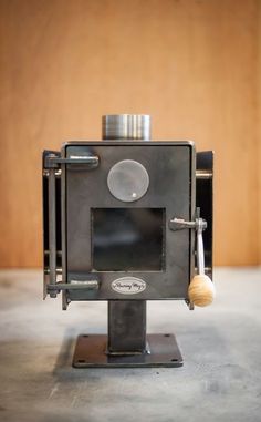 an old fashioned stove sitting on top of a metal stand