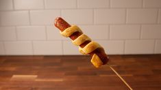 a hot dog on a stick with buns wrapped around it