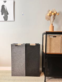 two storage boxes sitting next to each other on the floor in front of a wall