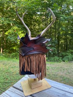 an animal's head with horns and fringes on top of a wooden table