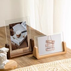 two wooden frames sitting on top of a table next to a cup of coffee and an open book