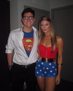 a man standing next to a woman wearing a superman costume