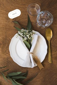 a white plate topped with flowers next to a fork and glass filled with water on top of a wooden table