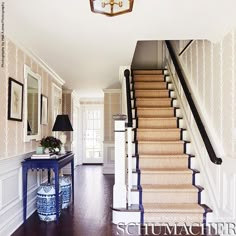 the stairs in this house are lined with blue and white rugs, along with an area rug on the floor