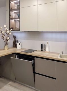 a modern kitchen with white cabinets and stainless steel dishwasher in the center area