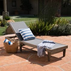 an empty chaise lounge on a patio with blue and white striped throw pillows,