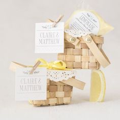 a small wooden basket with two tags attached to it and a lemon slice next to it