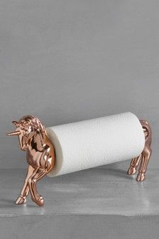 a toilet roll holder with a golden unicorn on it's side and a white paper towel in the middle