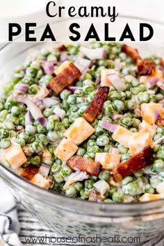 a bowl filled with peas, bacon and cheese on top of a white tablecloth