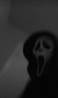 a person wearing a mask with their mouth wide open and tongue out in the dark