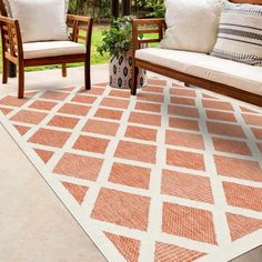 an outdoor area with two chairs and a rug