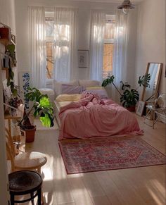 a living room filled with furniture and lots of windows covered in pink blankets on top of them