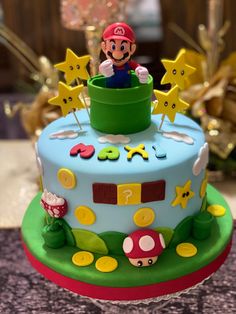 a birthday cake with mario on top and stars in the sky around it, sitting on a table