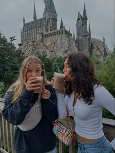 two girls drinking coffee in front of hogwarts castle