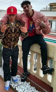 two young men posing for the camera on a balcony