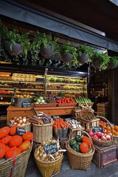 an outdoor market with lots of vegetables and fruits in baskets on the side of the road