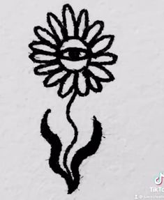 a drawing of a sunflower on the side of a white wall with black ink