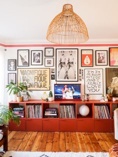 a living room filled with lots of pictures on the wall and furniture in front of it