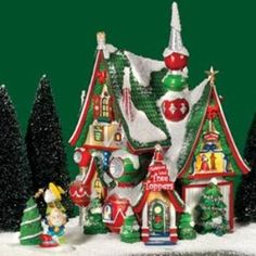 a small christmas village with trees and decorations on it's sides in front of a green background