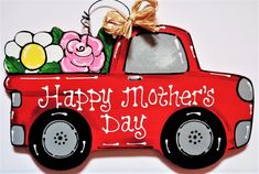 a happy mother's day sign with a red truck and flowers in the back