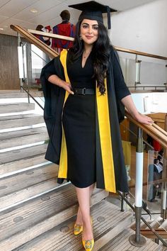 a woman wearing a graduation gown and yellow shoes is standing on the stairs in front of some steps