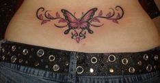 a woman's stomach with a butterfly tattoo on her belly and pink flowers in the center