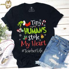 Product details:  TITLE NAME: Tiny Humans Stole My Heart Teacher Vintage T-Shirt, Teacherlife Shirt, Teacher Shirt, Christmas Shirt, Teacher Gift, Xmas Shirt  IMPORTANT NOTE: Both Men and Women can we our shirts because this is unisex style t-shirts;  Wash item inside out in cold water, do not bleach, do not dry clean, do not iron directly on the design.  MATERIAL: 5.3-ounce, 100% cotton (99/1 cotton/poly (Ash) & 90/10 cotton/poly (Sport Grey); Heavyweight classic unisex tee; Taped neck and shou Grinch Shirt, Grinch Shirts, Festival Shirts, Xmas Shirts, Tee Shirt Designs, Teacher Christmas, Tiny Humans, Christmas Shirt, Teacher Shirts