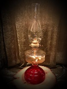 an old fashioned oil lamp is lit up in the dark