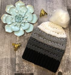 a knitted hat with a flower on the side and other items laying around it