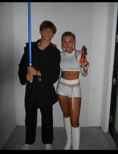 a man and woman dressed up as star wars characters holding lightsabens in their hands