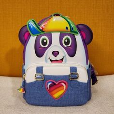 Add A Splash Of Color To Your Wardrobe With The Loungefly Lisa Frank Panda Painter Cosplay Mini Backpack. Make This The Perfect Gift For That Special Someone.... Or Just Treat Yourself! * * * * Features * * * * * Height 10" * Width 5.5" * Length 8" * Top Handle 2.5" * Padded Adjustable Rainbow Straps * Zip Closure * Gold Hardware * Faux Leather Exterior With Embroidered And Pvc Accents * 1 Front Zip Pocket With Cute Rainbow Paint Brush Charm * 2 Side Pouches * Interior Is Rainbow Panda Print * I Rainbow Paint, Loungefly Bag, Panda Print, Cute Rainbow, Novelty Bags, Lisa Frank, Paint Brush, Mini Backpack, Blue Purple