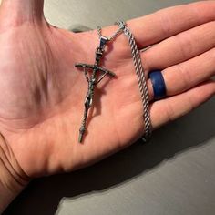 a person's hand with two rings and a cross on it