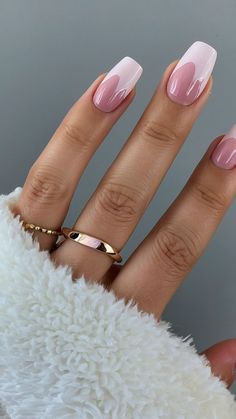 a woman's hand with pink nail polish and gold ring