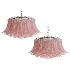 two pink chandeliers hanging from chains