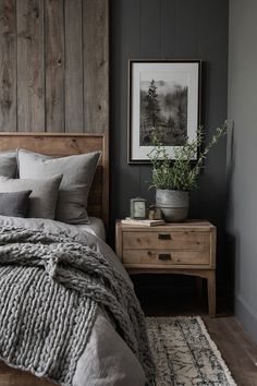 a bedroom with gray walls and wooden headboard, grey bedding, white rug