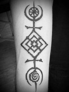 a black and white photo of a tattoo on someone's arm with an ornamental design