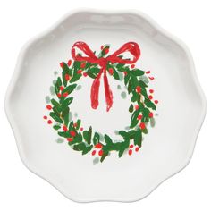 a white plate with a red bow and holly wreath on it