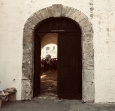 an arched doorway leading into a crowd of people