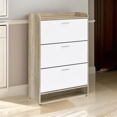 a white chest of drawers sitting next to a wooden cabinet in a room with beige walls