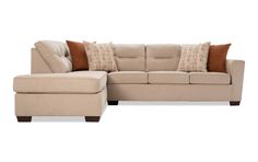 a beige sectional couch with pillows on it