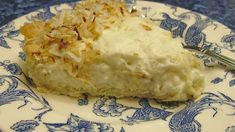 a piece of coconut cream pie on a blue and white plate