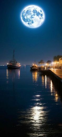 a full moon is seen over the water at night