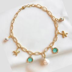 Capture the carefree and relaxed feeling of a day at the beach with our freshwater pearl charm necklace. Gold-filled charms of starfish, baby blue sea glass and merry-go-round pendants on a golden rope style chain add a laid-back luxury of coastal living. The large freshwater pearl adds a hint of sophistication making this necklace a perfect companion for breezy days and beachy nights. *Note: pearls may vary in size Size: 16 inches with a 1 inch extender Ocean-inspired Pearl Charm Necklace For Vacation, Blue Charm Necklaces For The Beach, Ocean-inspired Starfish Charm Necklace For Vacation, Vacation Ocean-inspired Starfish Charm Necklace, Pearl Charm Necklace, Stacked Necklaces, Blue Sea Glass, Bold Jewelry, Pearl Charms