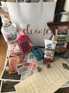 an assortment of snacks and candy sitting on top of a table next to a welcome sign