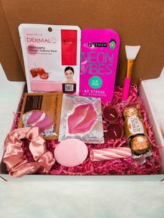 an open box filled with pink items on top of a bed