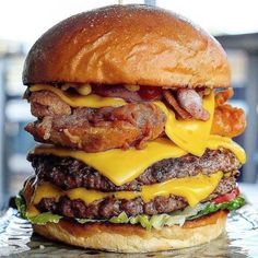 a large cheeseburger with bacon, lettuce and tomato