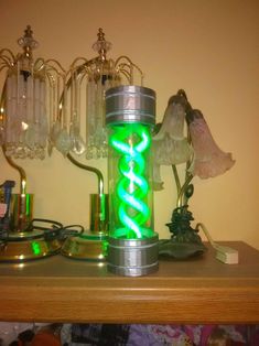 a green light sitting on top of a wooden table next to some glass vases